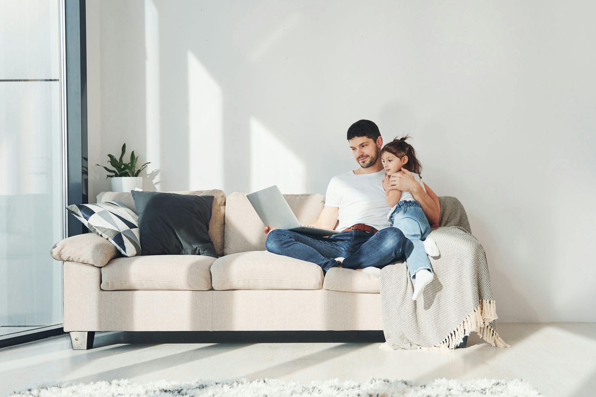 Patio with seating under a slatted pergola, overlooking a grassy backyard.