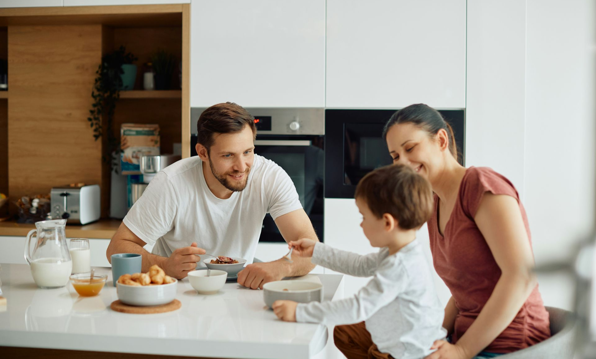 Patio with seating under a slatted pergola, overlooking a grassy backyard.