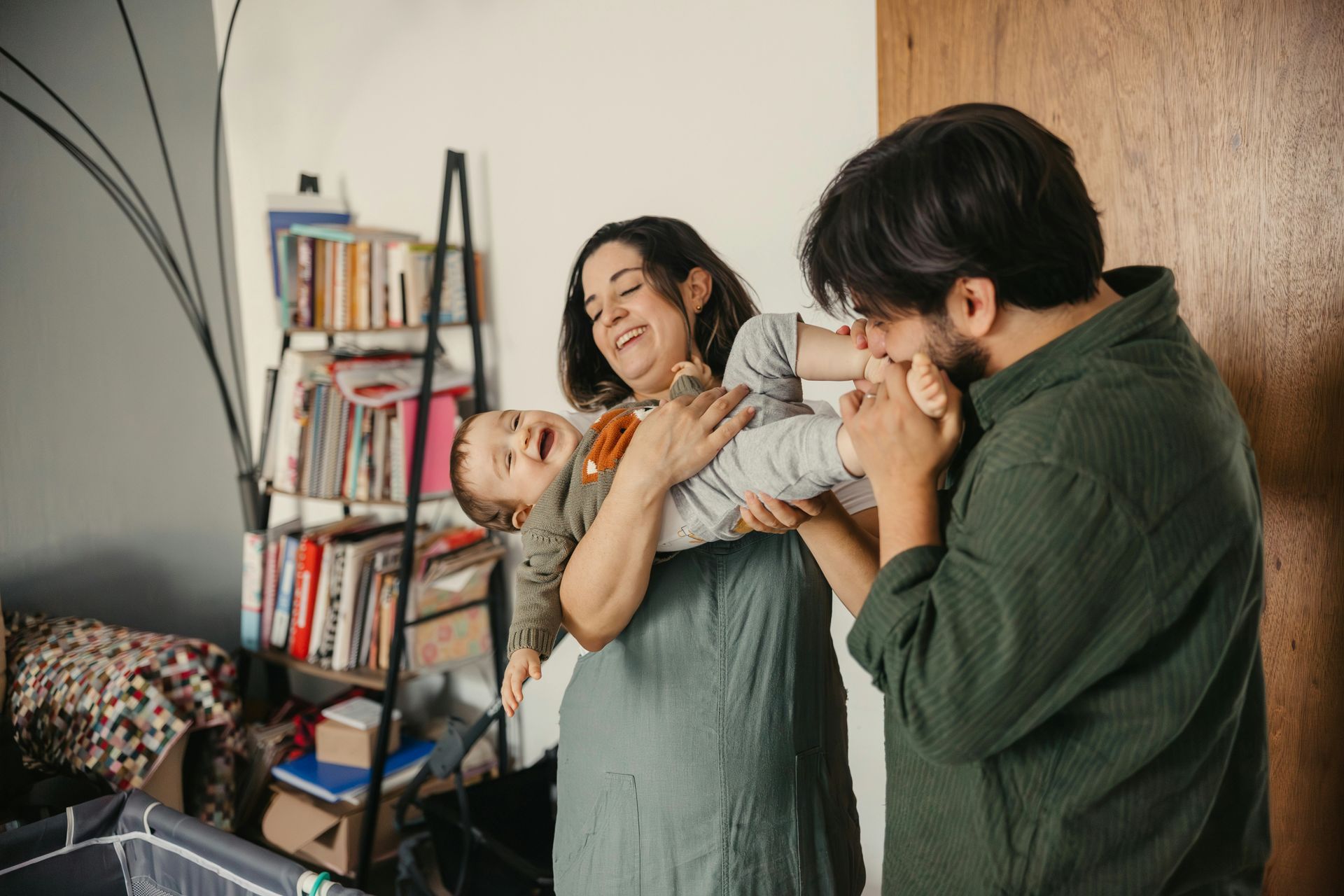Outdoor patio with light gray couches, white pergola, blue-trimmed windows, and stone floor.