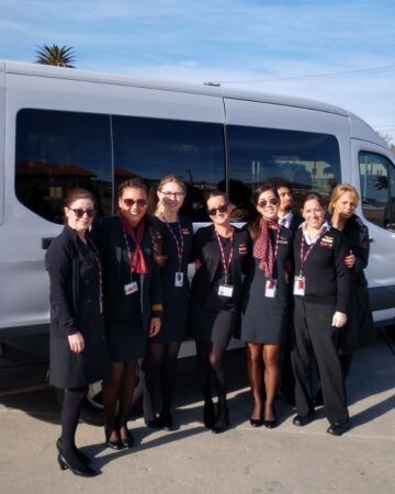 A group of women standing in front of a van