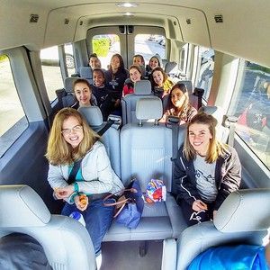 A group of people are sitting in the back seat of a van.