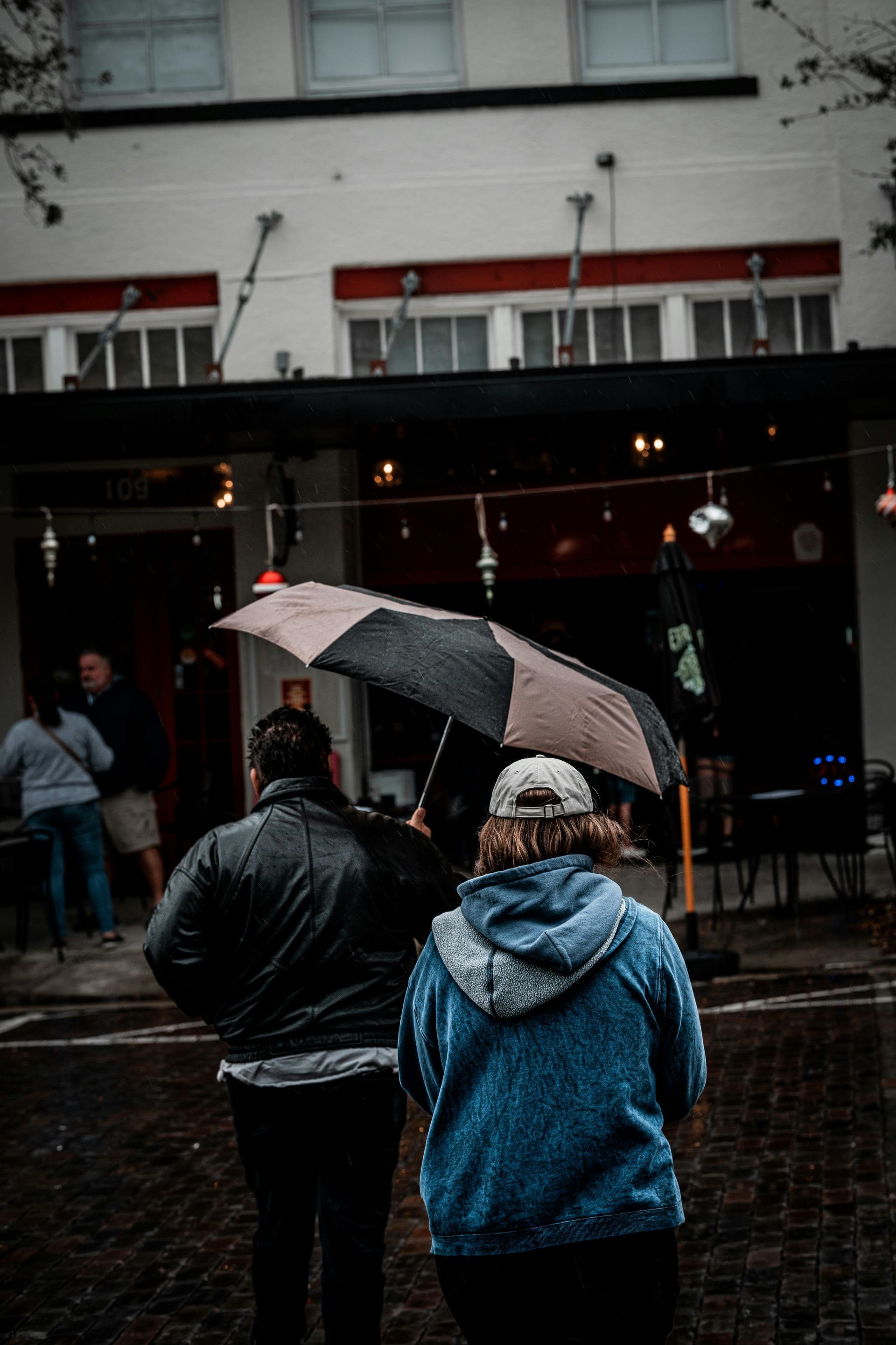 A group of people are walking in the rain with umbrellas.