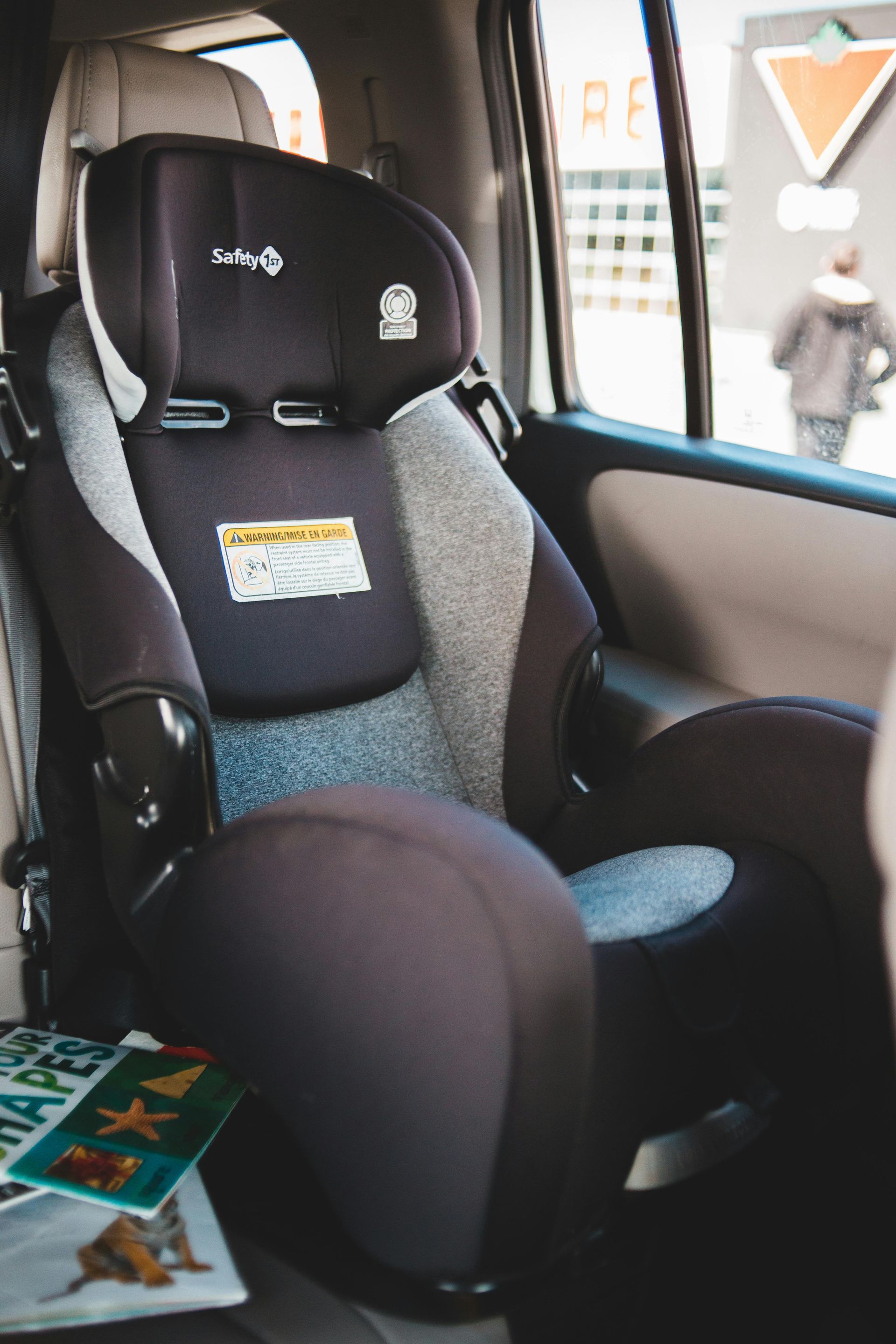 A car seat is sitting in the back seat of a car.