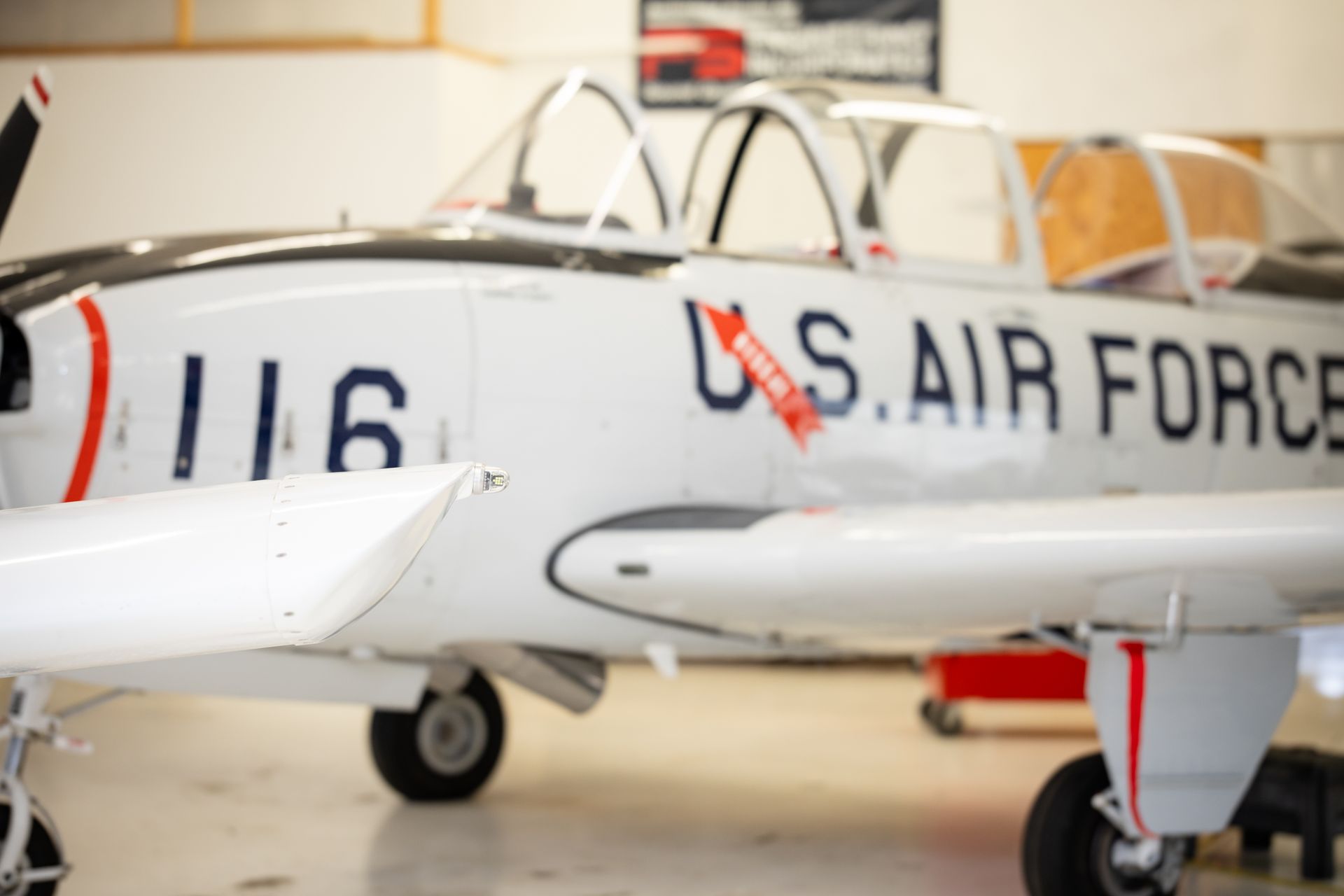 White U.S. Air Force jet in a hangar, nose number 116 visible
