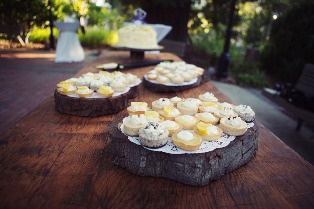 A wooden table topped with cupcakes and a cake.