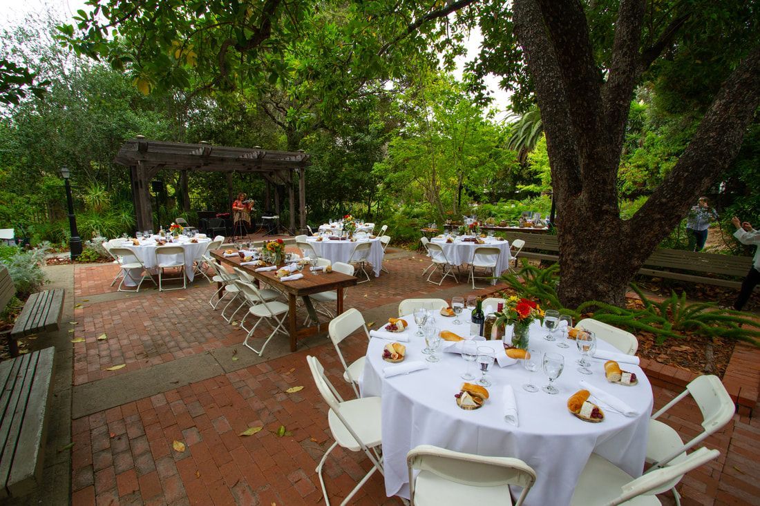 A patio with tables and chairs set up for a wedding reception.