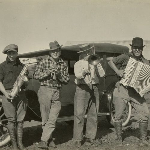 A group of men standing in front of a car playing instruments