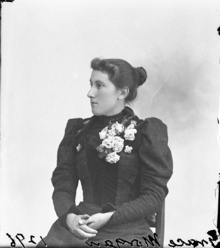 A black and white photo of a woman in a black dress