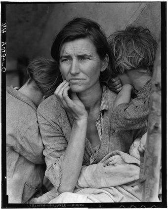 A black and white photo of a woman holding two children