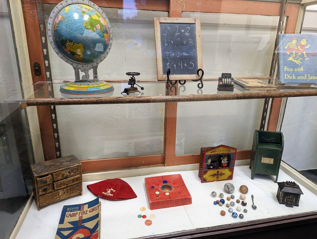 A display case with a globe , a chalkboard , a box , and other items on it.