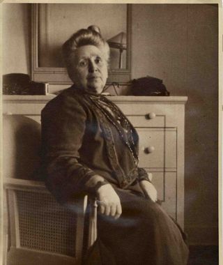 A black and white photo of a woman sitting in a chair