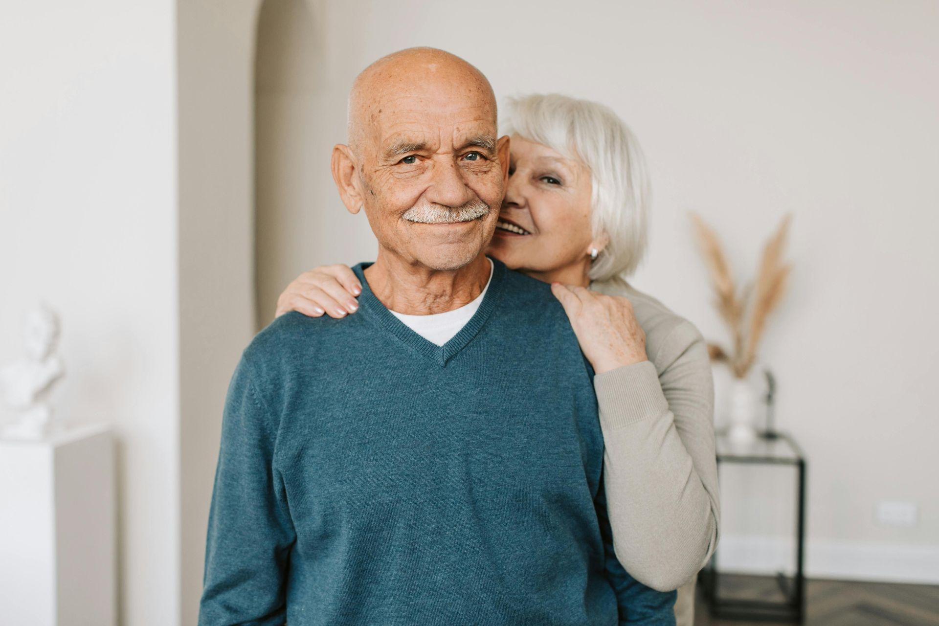A woman is kissing an older man on the cheek.