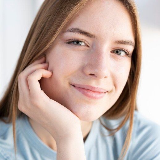 A close up of a woman 's face with her hand on her chin