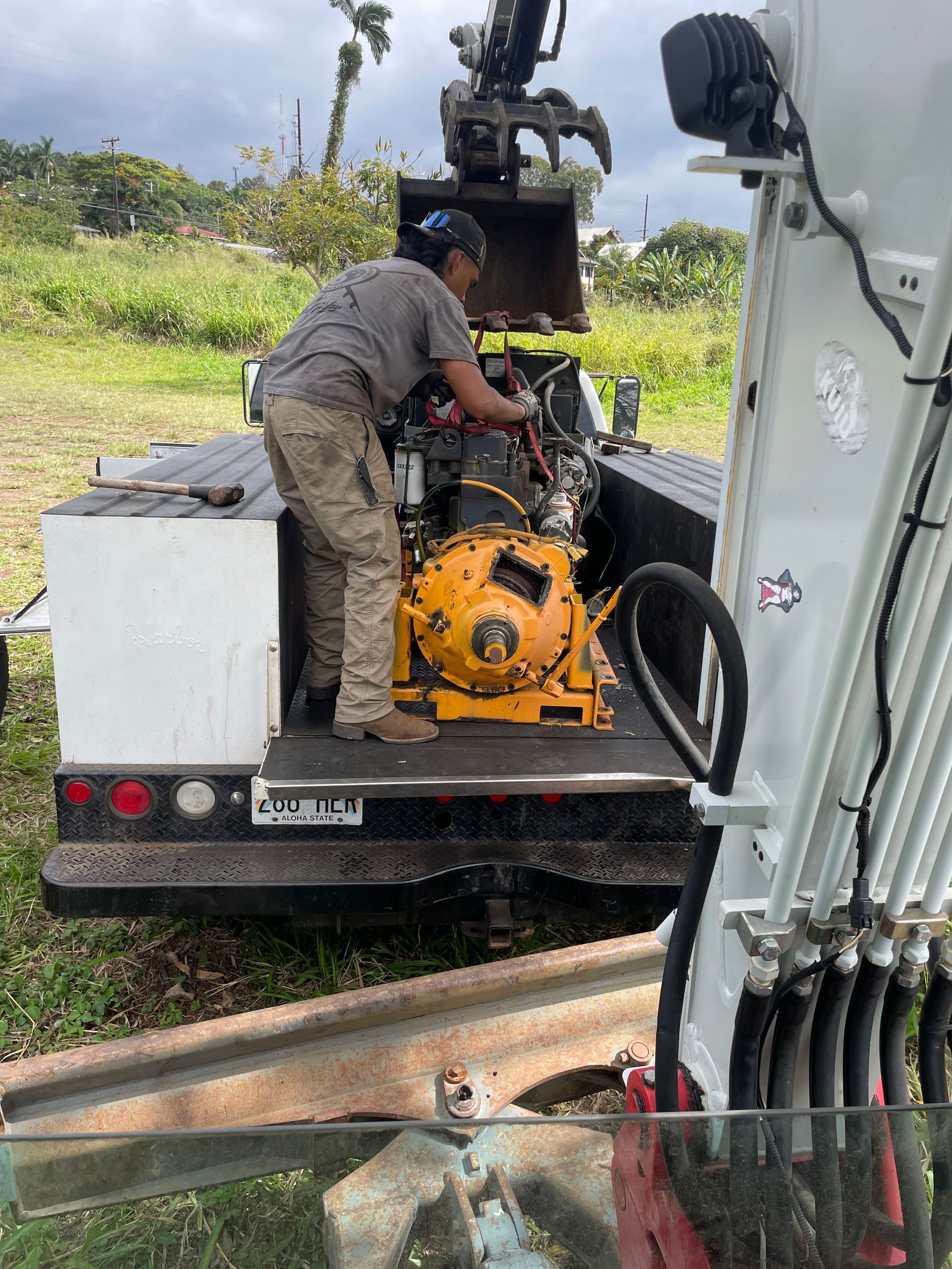 A man is working on a machine in the back of a truck.