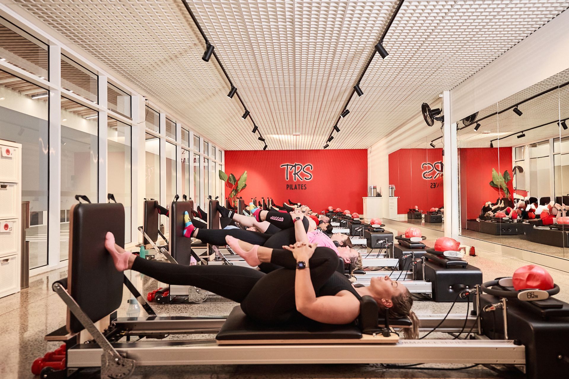 Reformer Pilates at TRS Pilates Ballarat. Members laying on reformer Pilates Beds stretching.