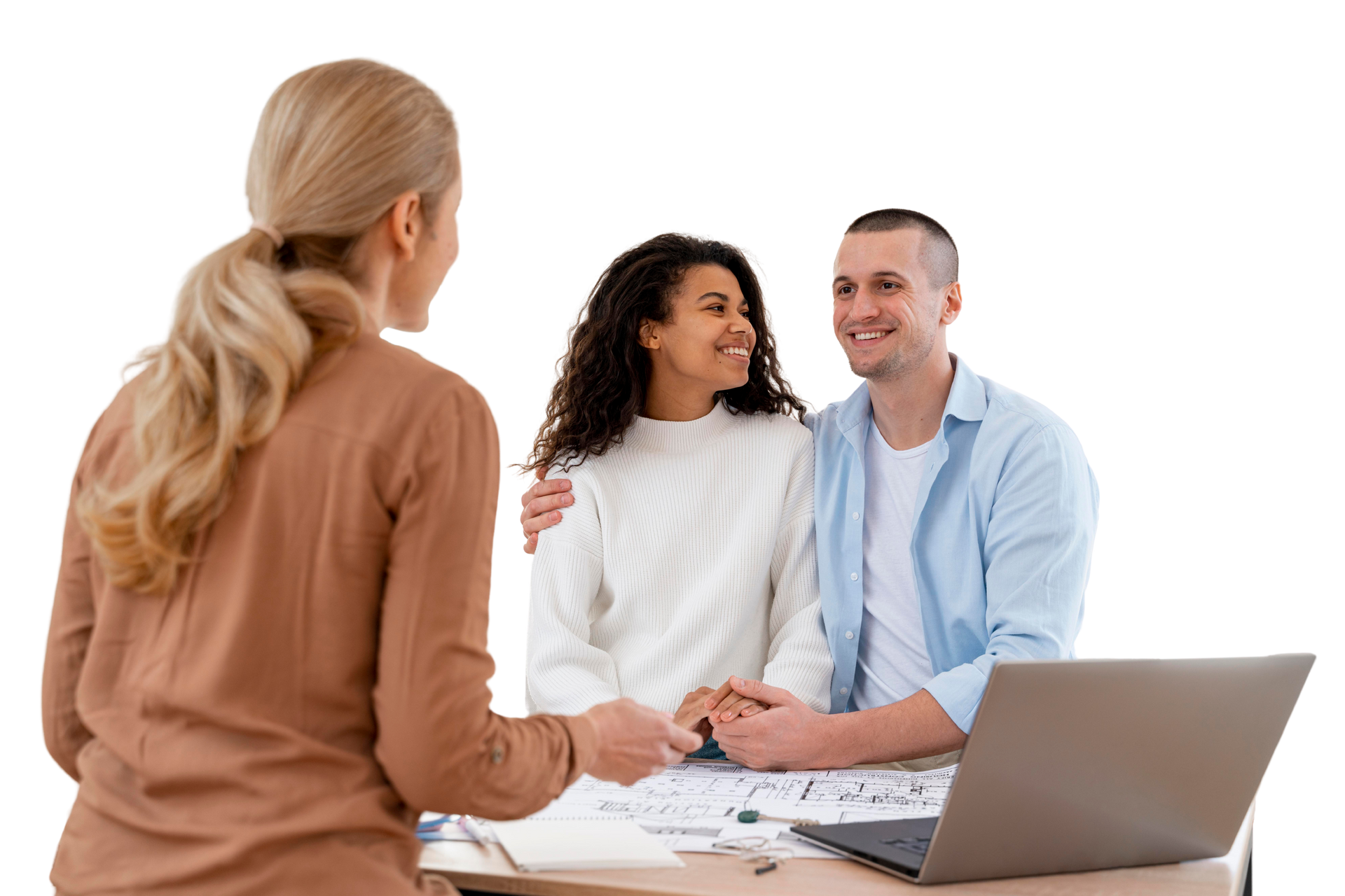 A woman hands keys to a smiling couple, who are seated at a table with a laptop and blueprints.