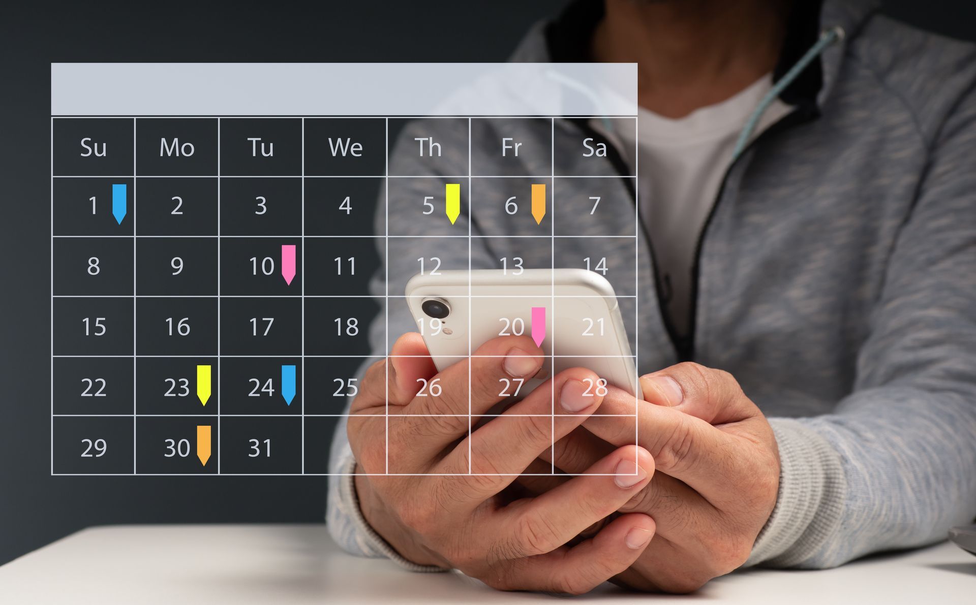 Hands holding a glowing virtual calendar with marked dates and times over a desk Hands holding a glowing virtual calendar with marked dates and times over a desk