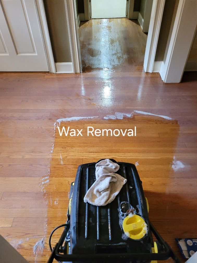 A vacuum cleaner is being used to remove wax from a wooden floor.