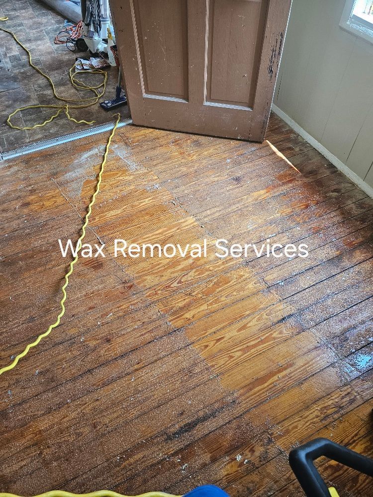 A wooden floor in a room with a door and a cord.