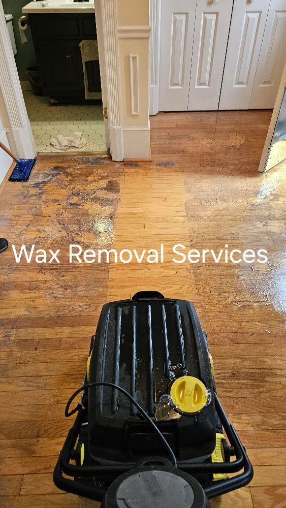 A machine is cleaning a wooden floor in a room.