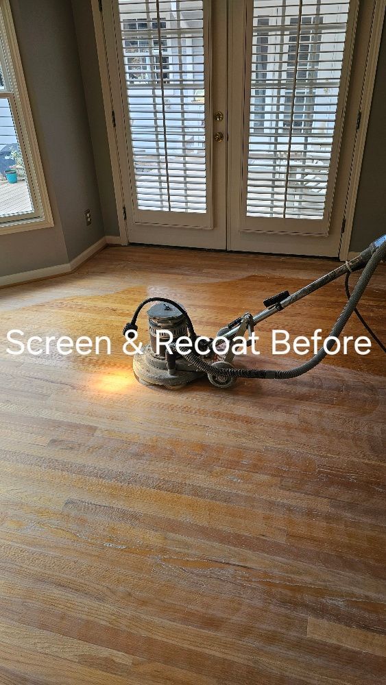 A vacuum cleaner is sitting on a wooden floor in a living room.