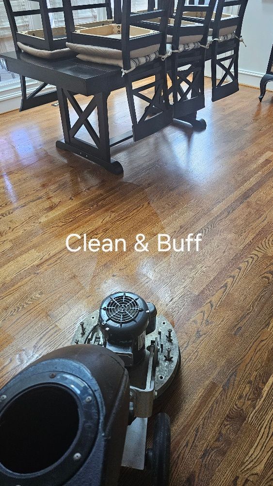 A machine is cleaning a wooden floor in a dining room.