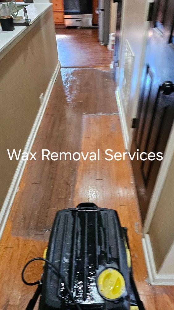 A vacuum cleaner is cleaning a wooden floor in a hallway.