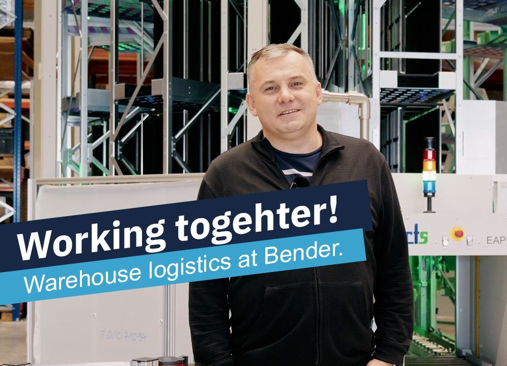 Man in black jacket smiles in warehouse setting with 