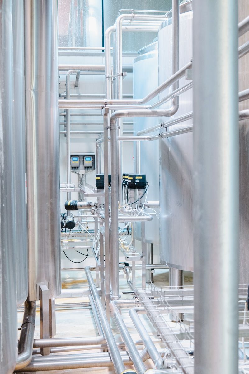 A row of stainless steel pipes in a factory.