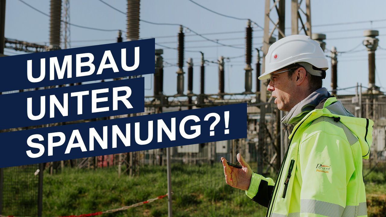 A man is standing in front of a sign that says umbau unter spannung