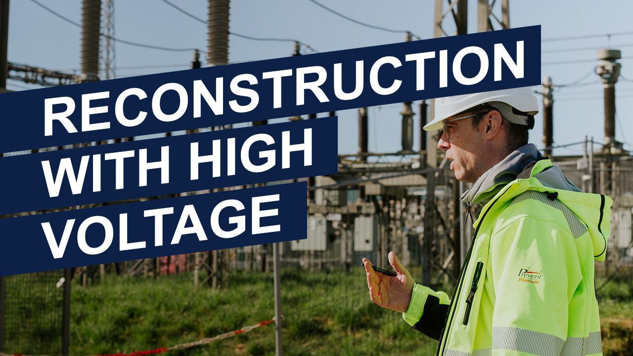 A man is standing in front of a sign that says reconstruction with high voltage.