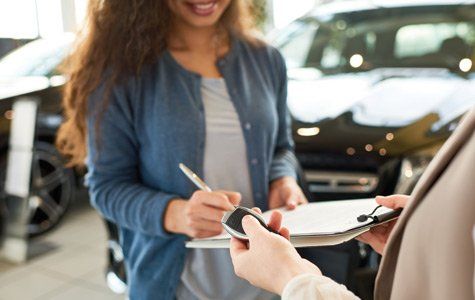 Car Dealer License — Woman Signing a Contract in Delran, NJ