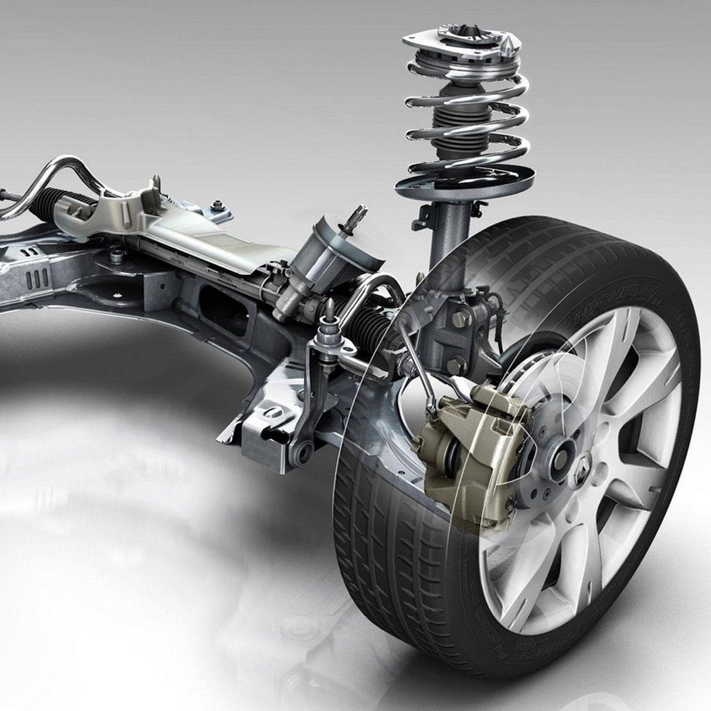 Sistema de suspensión delantera de un automóvil. Se muestran la rueda, el neumático, los componentes del freno y el amortiguador. Piezas plateadas y negras sobre fondo blanco.
