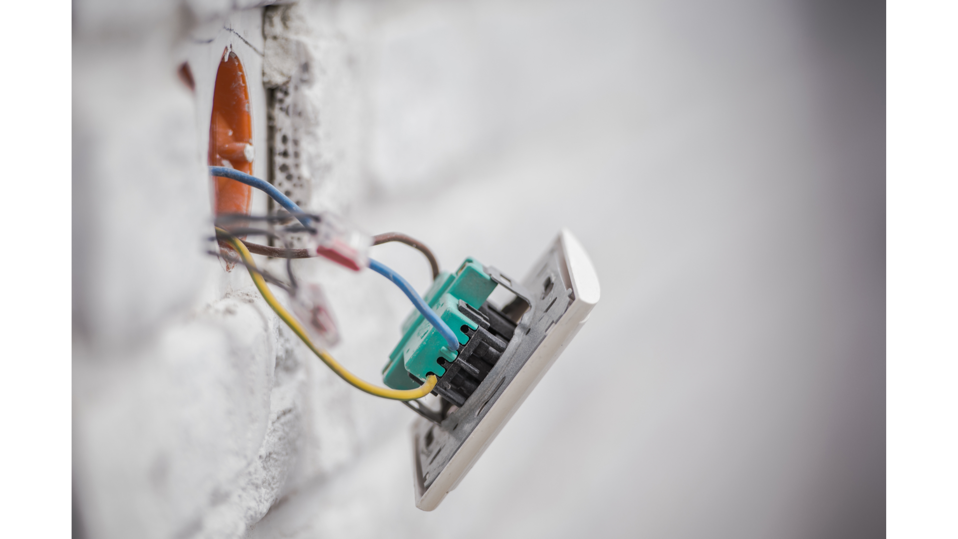 A close up of an electrical outlet with wires coming out of it.