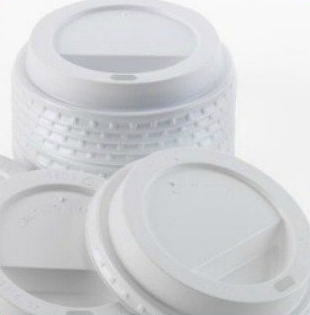 A stack of white coffee cup lids sitting on top of each other.