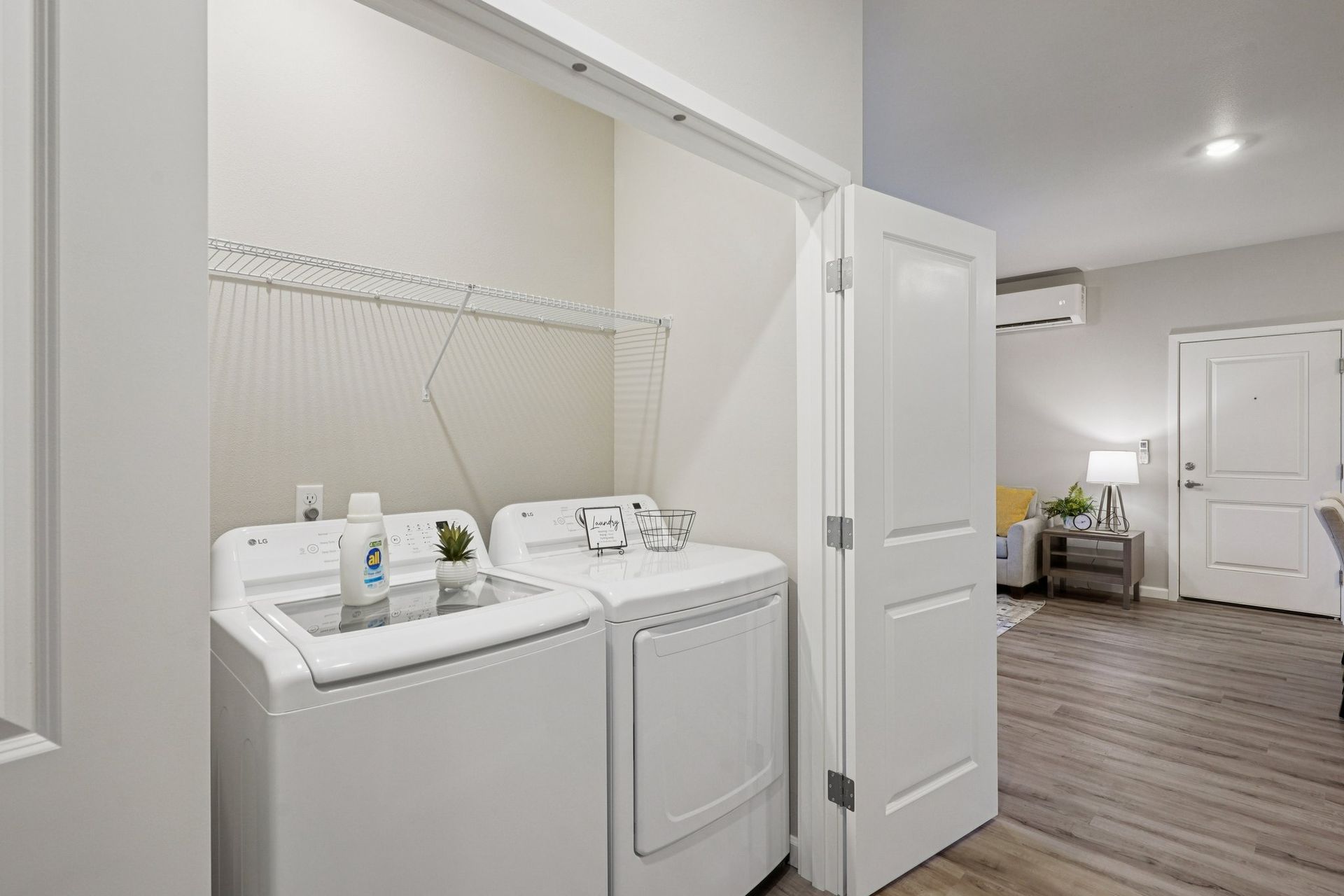 Laundry area with white washer and dryer beside a hallway and open door