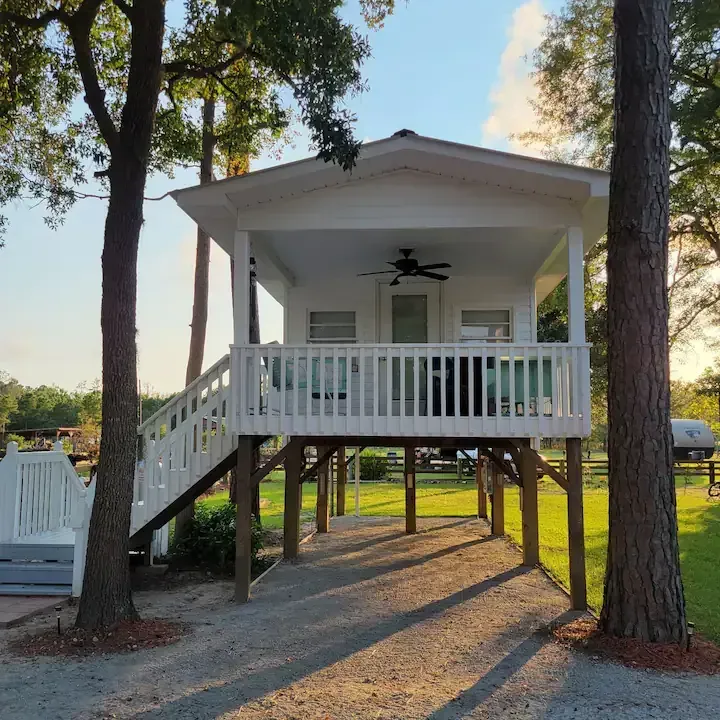 A small white house with a porch and stairs