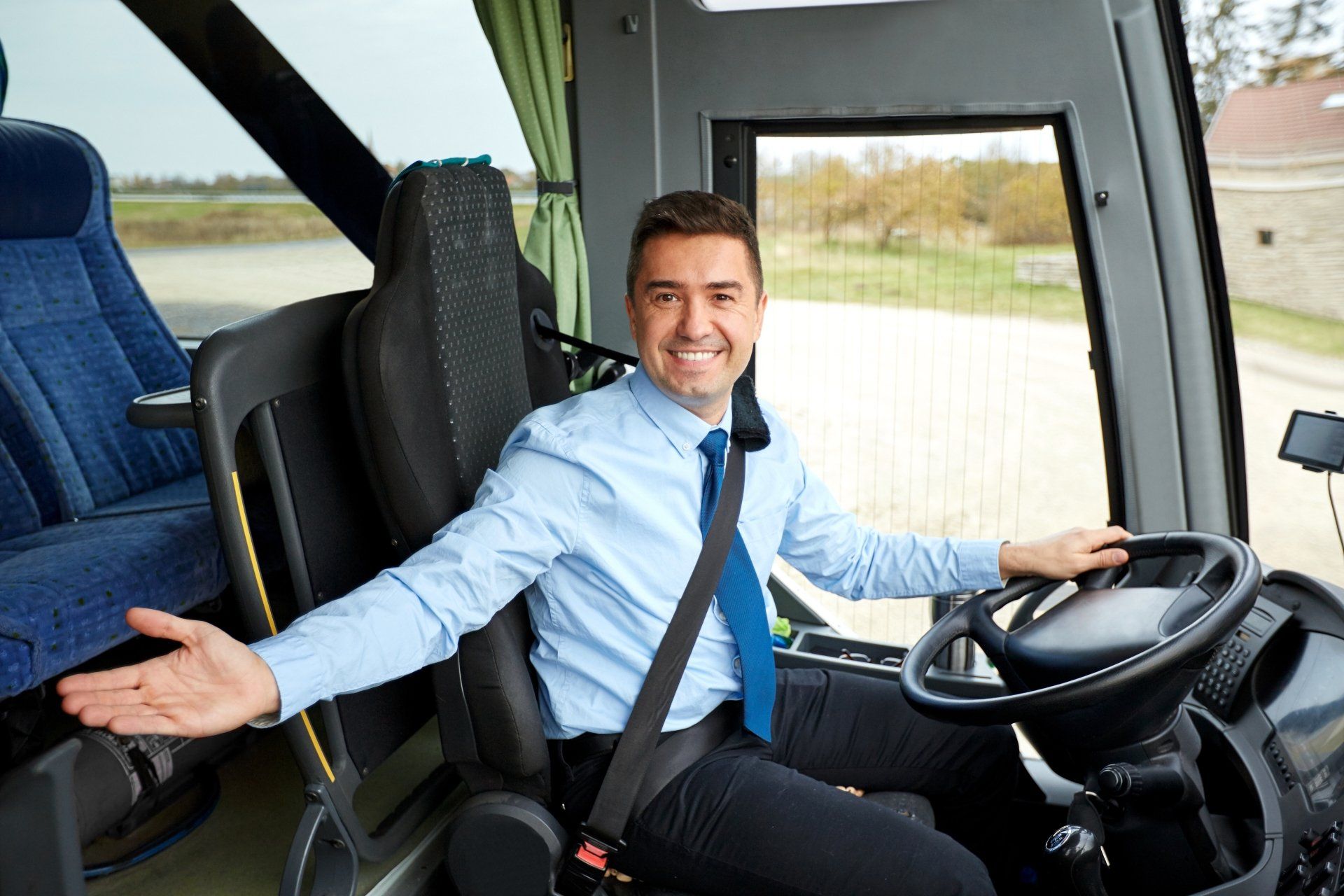 Conductor de autobús sonriente con camisa azul claro y corbata azul,