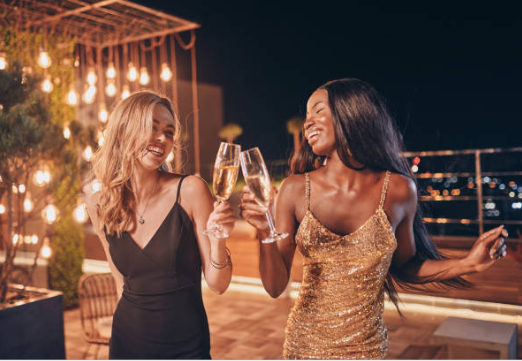 Two women are toasting with champagne glasses at a party.