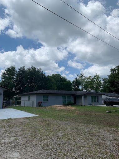 A house with a lot of grass in front of it and a truck parked in front of it.