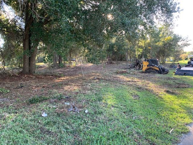 A bulldozer is sitting in the middle of a grassy field.