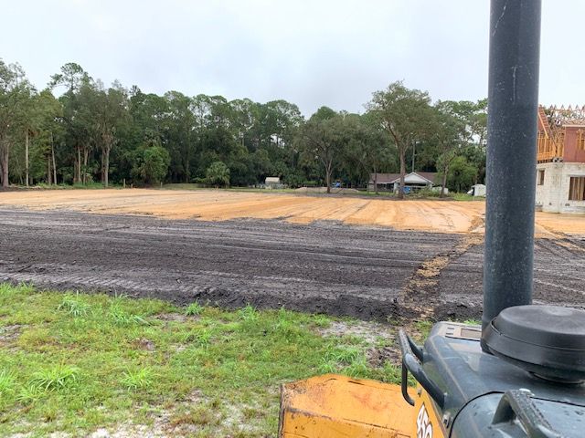 A bulldozer is sitting in the middle of a dirt field.