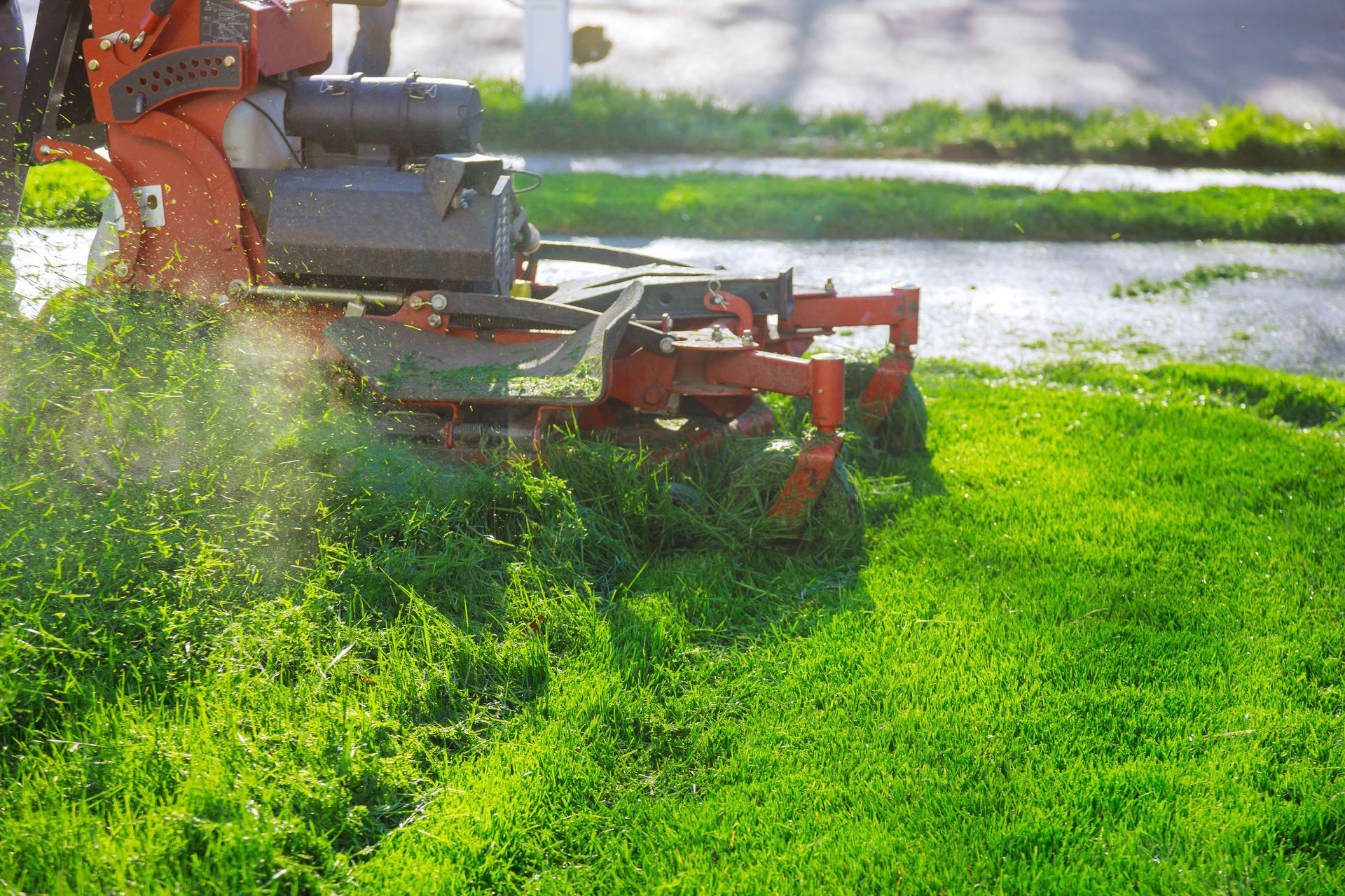 A person is riding a lawn mower on a lush green lawn.