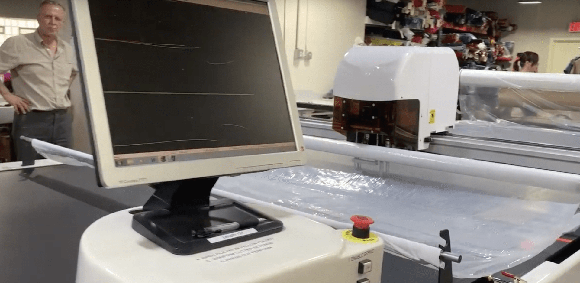 A computer monitor is sitting on top of a table next to a machine.