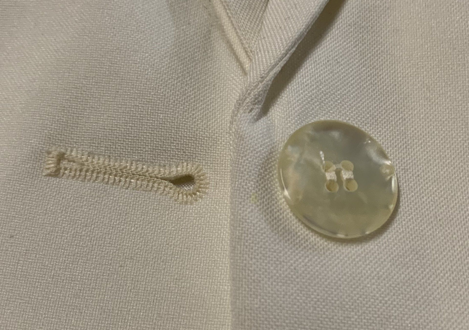 A close up of a button on a white jacket