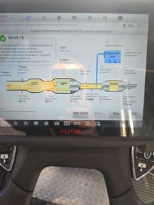 A computer screen shows a diagram of a car exhaust system