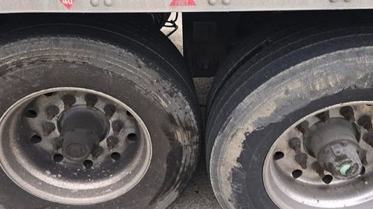 A close up of a truck 's tires and wheels.