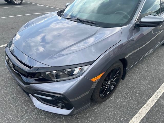 Gray Honda Civic car parked in a parking lot on an overcast day.