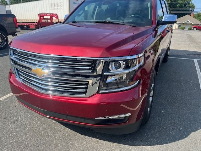 Red Chevrolet Tahoe SUV parked outside on a sunny day.