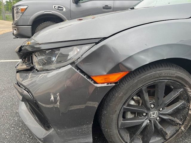 Damaged gray Honda Civic with crumpled front end, likely from a collision.